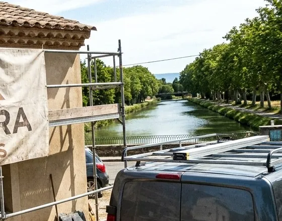 Échafaudage d’un chantier de toiture au bord du canal à Sallèles-d’Aude, platanes et chemin de halage